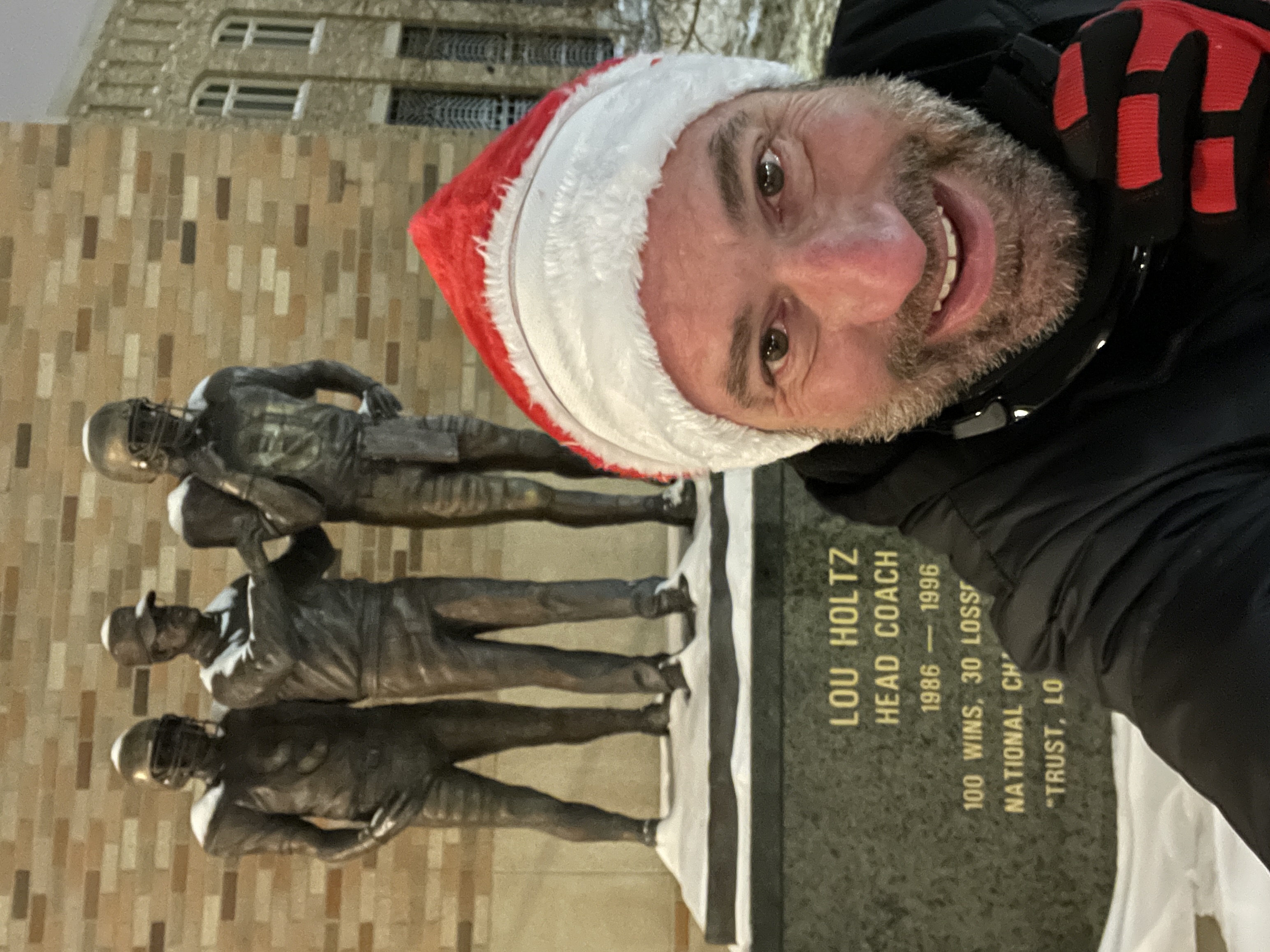 Matthew Owen visiting the Lou Holtz monument on a snowy Notre Dame campus