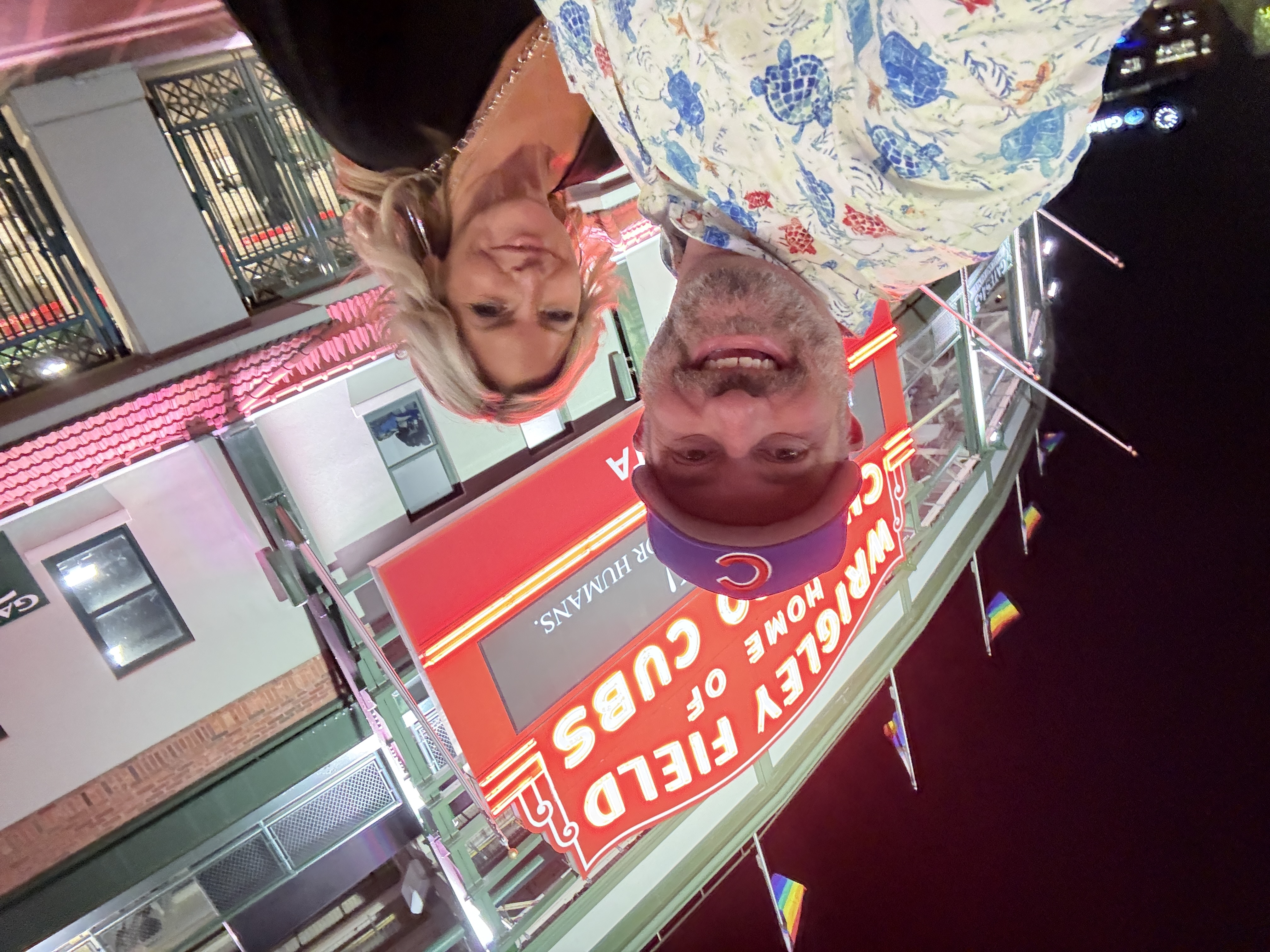 Matt and a companion in front of the illuminated Wrigley Field marquee
